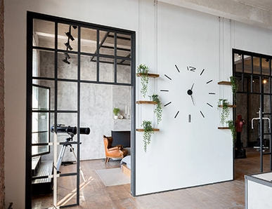 Türen im Loft-Stil mit schwarzen Metallrahmenelementen verbinden Küche und Wohnbereich.
