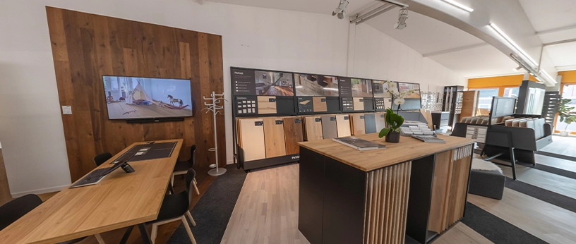 Verschiedene Parkett- und Dielenmuster samt Sockelleisten und Prospekten in geordneter Bodenausstellung.