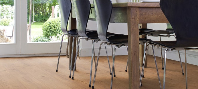 Das Esszimmer ist mit Laminat in hellem Holzfarbton ausgelegt. Ein massiver Esstisch aus Holz und leichte Stühle runden die Einrichtung ab.