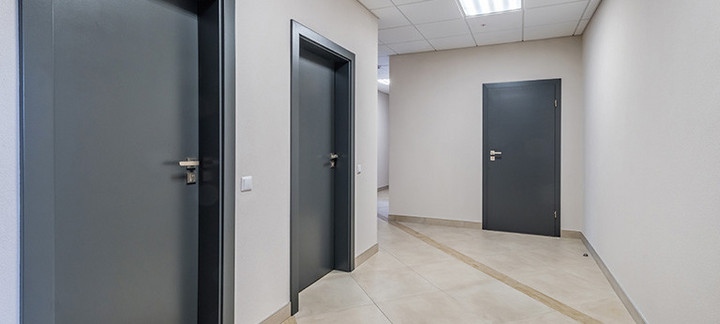 Mehrere anthrazitfarbene Wohnungstüren, Blick vom Treppenhaus.